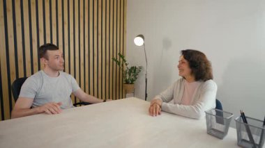 İki meslektaş bir internet görüşmesinde fikir ve projeleri tartışıyor. Kurulumda bitkiler ve sıcak bir atmosferi olan rahat bir ev ofisi, işbirliği için rahat bir ortam yaratıyor..