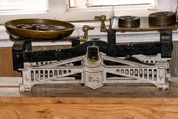 Vintage metal scales for a store with weights on a wooden table
