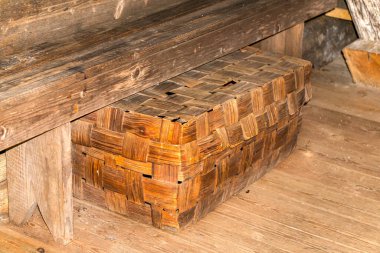 Hamamda banyo aksesuarları için eski bir hasır kutu.