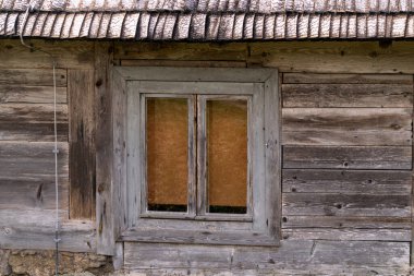 Eski ahşap bir evin ahşap duvarındaki eski ahşap pencere.