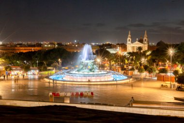 Gün batımının erken saatlerinde Valletta girişinde, ortada Triton çeşmesi var.