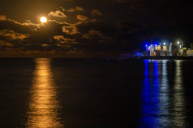 Red full moon of January, 2023, shined bright like it was the sun setting on the sea horizon