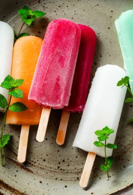 group of colored ice cream on a stick on white. summer dessert
