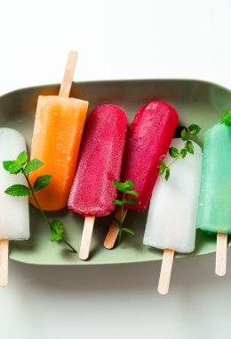 group of colored ice cream on a stick on white. summer dessert