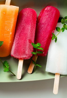 group of colored ice cream on a stick on white. summer dessert
