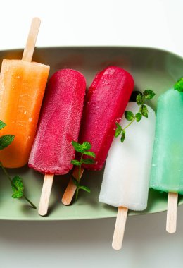 group of colored ice cream on a stick on white. summer dessert