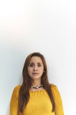 Beyaz arka planda sarı gömlekli kadın korkmuş.