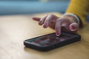 Kadın eli cep telefonu tutuyor.