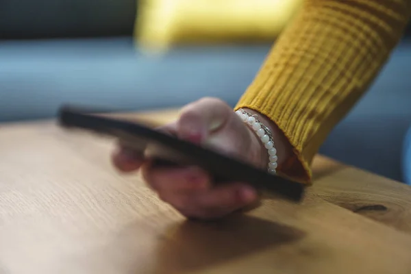 Kadın eli cep telefonu tutuyor.