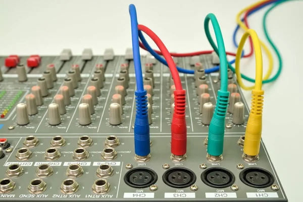 Müzik konsolu bağlı ses kablosu ile karıştırılıyor. Müzik enstrümanını bağlamak ve kaydetmek için farklı renk ses kabloları.