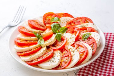 Dilimlenmiş domates, mozzarella, fesleğen, zeytin yağı ile İtalyan Caprese salatası