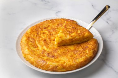 Spanish omelette with potatoes, typical spanish cuisine on gray concrete floor. Tortilla Espanola. Turkish name; Yumurtali patates
