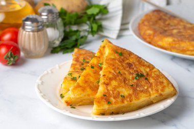 Spanish omelette with potatoes, typical spanish cuisine on gray concrete floor. Tortilla Espanola. Turkish name; Yumurtali patates