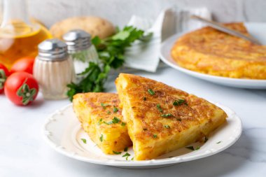 Spanish omelette with potatoes, typical spanish cuisine on gray concrete floor. Tortilla Espanola. Turkish name; Yumurtali patates