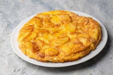 Spanish omelette with potatoes, typical spanish cuisine on gray concrete floor. Tortilla Espanola. Turkish name; Yumurtali patates
