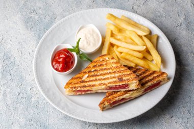 Türk tostu, çedar peyniri, sosis ve jambonla karıştırılmış tost, kızarmış patates (Türk adı Karisik tost))