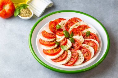 Dilimlenmiş domates, mozzarella, fesleğen, zeytin yağı ile İtalyan Caprese salatası