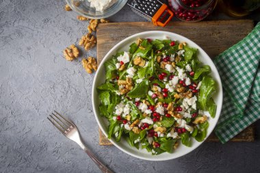 Ceviz ve nar ile servis edilen peynirli Arugula salatası. Türkçe adı: Roka salatasi