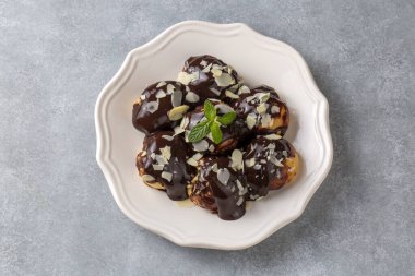 Çikolatalı ve beyaz tabaklı lezzetli profiteroller..