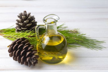 Cam şişedeki çam yağı, kozalaklı yapraklar ve çam kozalağı. Kiefer terebentin