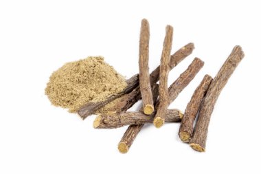 Meyan kökleri ve meyan kökü tozu beyaz arkaplanda.