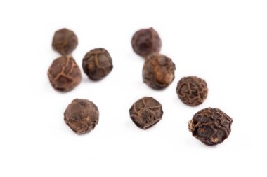 Beyaz arka planda kurumuş siyah biber.