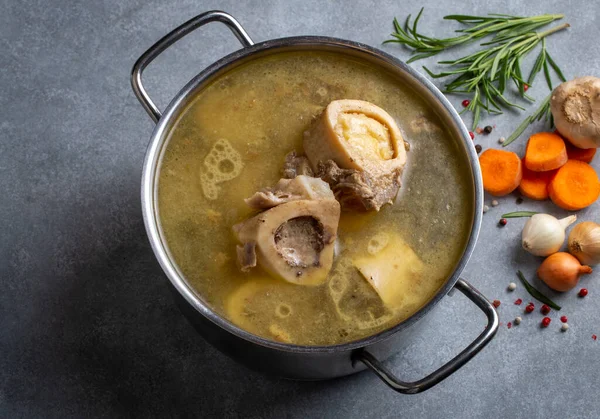 Boiled bone and broth. Homemade beef bone broth is cooked in a pot on. Bones contain collagen, which provides the body with amino acids, which are the building blocks of proteins.