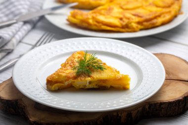 Spanish omelette with potatoes, typical spanish cuisine on gray concrete floor. Tortilla Espanola. Turkish name; Yumurtali patates