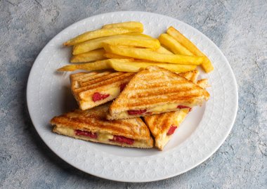 Türk tostu, çedar peyniri, sosis ve jambonla karıştırılmış tost, kızarmış patates (Türk adı Karisik tost))