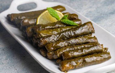 Delicious dolma (sarma) stuffed grape leaves rice. Lebanese dolma sarma on plate. Lebanon turkish greek middle eastern cuisine. (Turkish name; Yaprak sarma) clipart