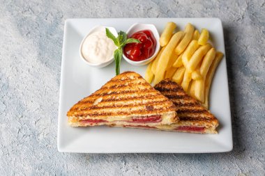 Türk tostu, çedar peyniri, sosis ve jambonla karıştırılmış tost, kızarmış patates (Türk adı Karisik tost))