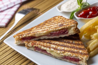 Türk tostu, çedar peyniri, sosis ve jambonla karıştırılmış tost, kızarmış patates (Türk adı Karisik tost))