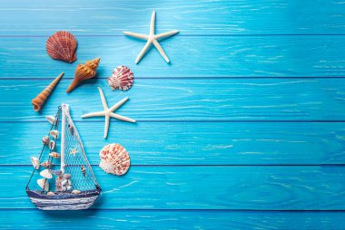 Yaz tatili geçmişi, deniz kabukları, ahşap mavi arka planda yıldız..