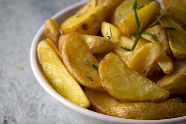 Kızarmış patates kamışı, otlar ve tabakta deniz tuzu, üst görünüm (Türk adı; elma dilim patatesi))