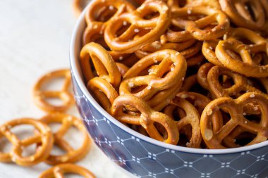 Ahşap arka planda tuzlu mini krakerler. Seçici odak.