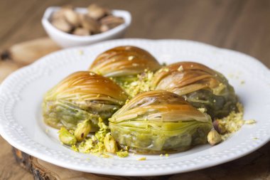 Yeşil şam fıstığı tozu ve tereyağı kremalı Türk Midye Baklava 'sı (Midye Baklava). İslami Ziyafetler Kavramı.