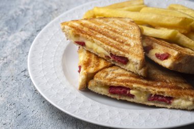 Türk tostu, çedar peyniri, sosis ve jambonla karıştırılmış tost, kızarmış patates (Türk adı Karisik tost))