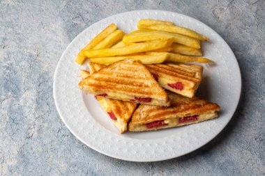 Türk tostu, çedar peyniri, sosis ve jambonla karıştırılmış tost, kızarmış patates (Türk adı Karisik tost))