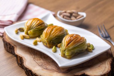 Yeşil şam fıstığı tozu ve tereyağı kremalı Türk Midye Baklava 'sı (Midye Baklava). İslami Ziyafetler Kavramı.