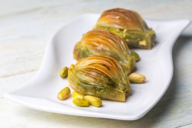 Yeşil şam fıstığı tozu ve tereyağı kremalı Türk Midye Baklava 'sı (Midye Baklava). İslami Ziyafetler Kavramı.