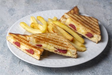 Türk tostu, çedar peyniri, sosis ve jambonla karıştırılmış tost, kızarmış patates (Türk adı Karisik tost))