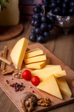 Kashar peyniri ya da ahşap zeminde kaşkaval peyniri. Servis panosunda peynir dilimleri (Türkçe isim; Kars Kasari)