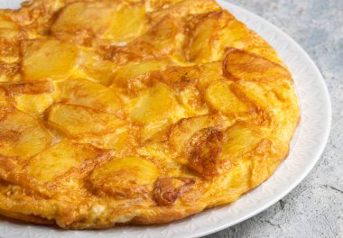 Spanish omelette with potatoes, typical spanish cuisine on gray concrete floor. Tortilla Espanola. Turkish name; Yumurtali patates