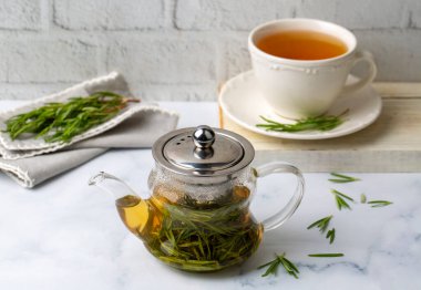 Taze biberiyeli bir fincan sağlıklı biberiye çayı. Kırsal arka planda, kış bitkisi sıcak içecek konsepti, salvia rosmarinus.