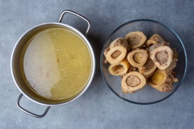 Kaynamış kemik ve et suyu. Ev yapımı sığır eti çorbası tencerede pişirilir. Kemikler, vücuda proteinlerin yapı taşları olan amino asitleri sağlayan kolajen içerir..