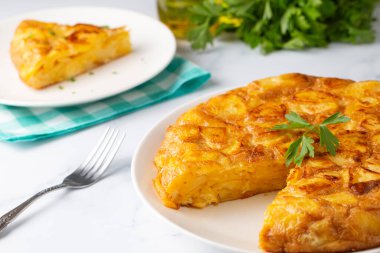 Spanish omelette with potatoes, typical spanish cuisine on gray concrete floor. Tortilla Espanola. Turkish name; Yumurtali patates