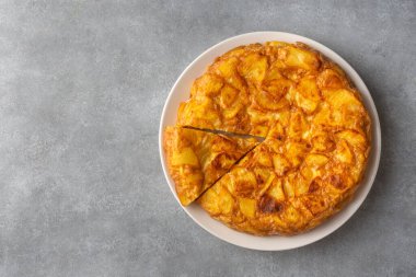 Spanish omelette with potatoes, typical spanish cuisine on gray concrete floor. Tortilla Espanola. Turkish name; Yumurtali patates