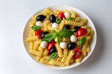 İtalyan soğuk makarna salatası ya da makarna fredda alla caprese. Tam üstte. Fusilli, domates, mozzarella, zeytin, roka. Türk ismi; burgu makarna salatasi