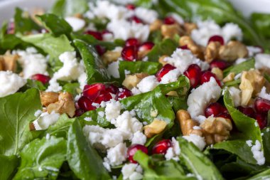 Ceviz ve nar ile servis edilen peynirli Arugula salatası. Türkçe adı: Roka salatasi