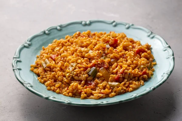 stock image Traditional turkish bulgur pilaf with tomato sause in plate (Turkish name; meyhane pilavi)